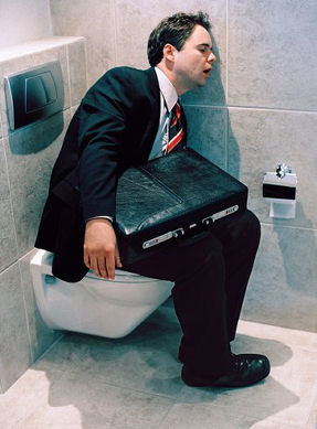 Businessman sleeping on toilet
